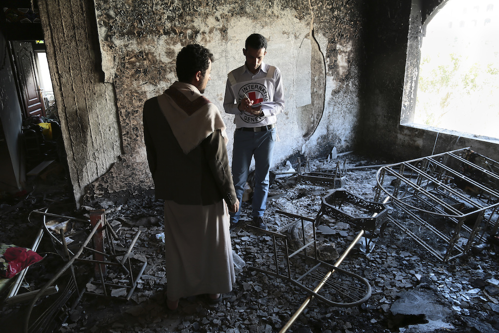 Sa’ana, Yemen. A man looks out of the window as he talks with an ICRC employee evaluating the damage done to a civilian building. April 2015. Humanitarian engagement (ICRC/Thomas Glass)