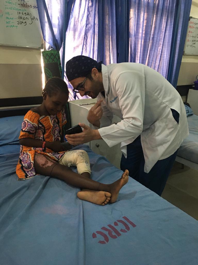 الدكتور أكثم الفرنواني مع طفلة مصابة بكسر في الفخذ نتيجة إطلاق نار في مايدوغوري