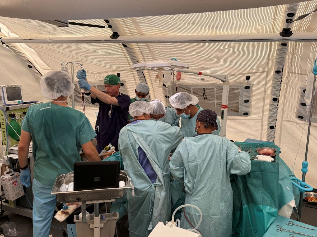 فريق جراحي يعالج مصابًا في غرفة عمليات ميدانية أثناء طارئ جماعي خلال الحرب في غزة