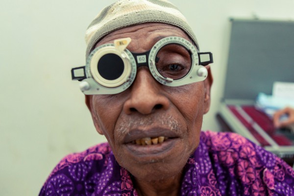 בּוּרוּ, חולה נוסף עובר מדידה לפני שיוכל לקבל משקפי קריאה בחינם.