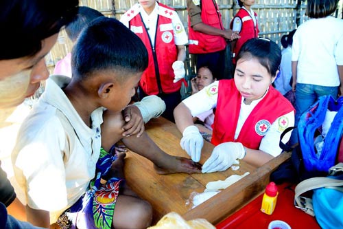 Negara bagian Rakhine, Myanmar. Dengan dukungan ICRC, Palang Merah Myanmar memberikan pertolongan pertama bagi orang-orang sakit dan terluka dari kedua kelompok. Di tempat dengan kondisi hidup yang sangat sulit, luka kecil bisa berdampak serius jika tidak ditangani dengan baik. © ICRC / Aye Zaw Myo / v-p-mm-e-00135