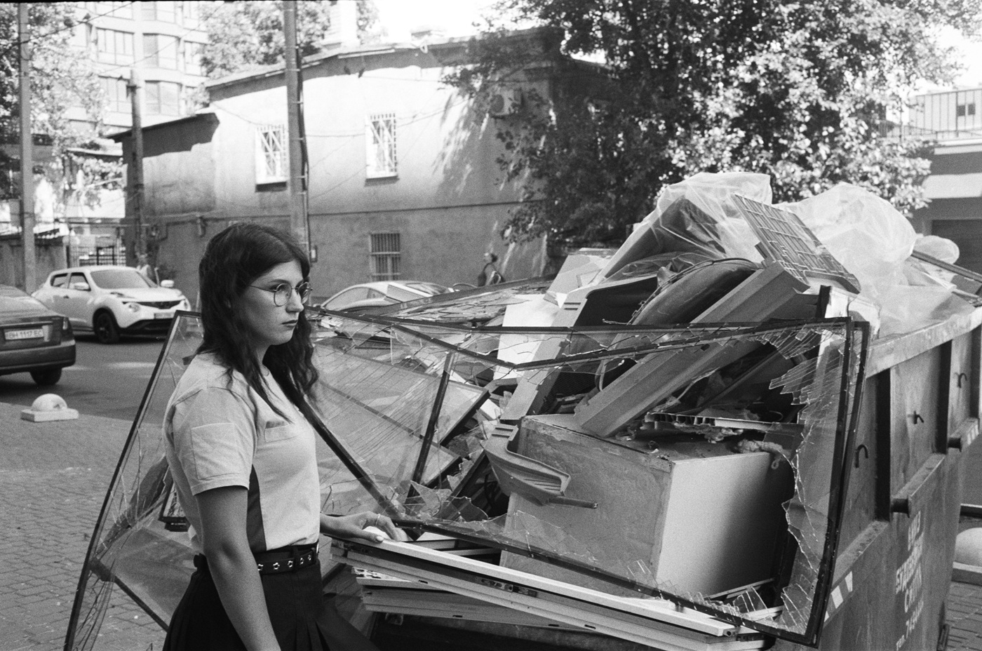 Вікторія та розтрощені віконні рами з її квартири, пошкодженої внаслідок удару дрону.