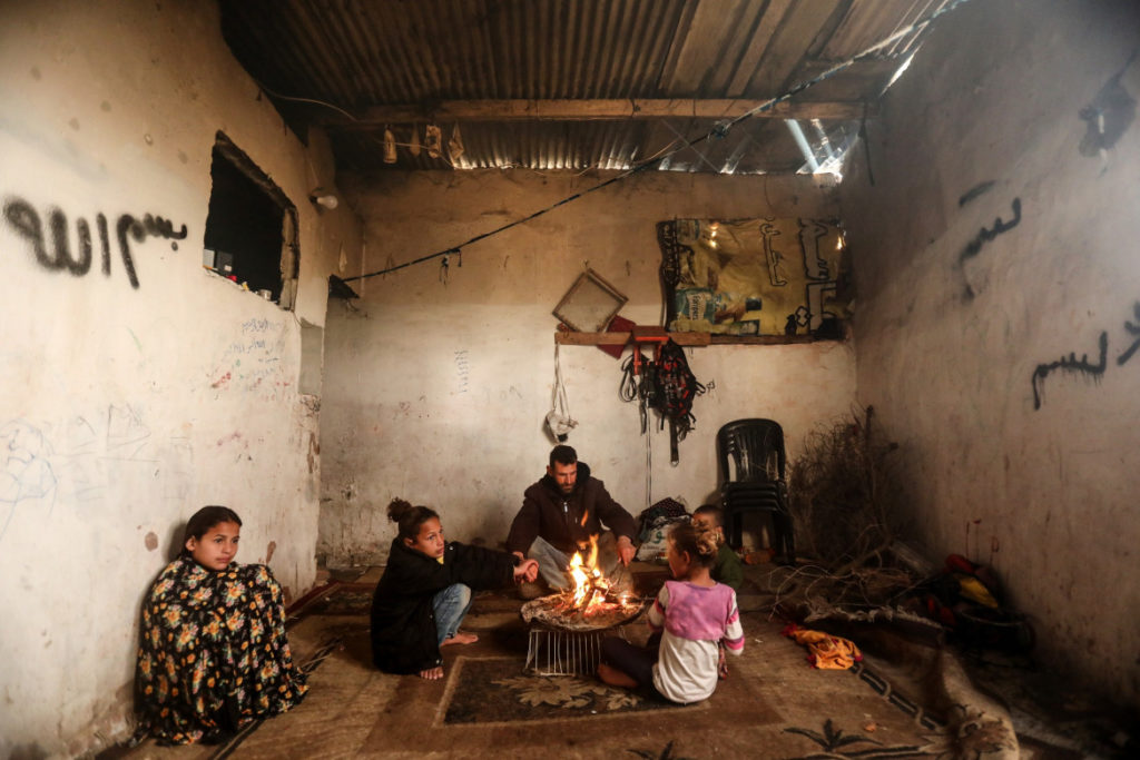 La famille de Samarat assise autour du feu pour se réchauffer durant l’hiver.