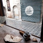 Old city, Aleppo, Part of a mortar bomb lies in the remains of a shop window, its deadly menace contrasting oddly with pieces of life-giving bread. / CC BY-NC-ND / ICRC / H. Hvanesian 