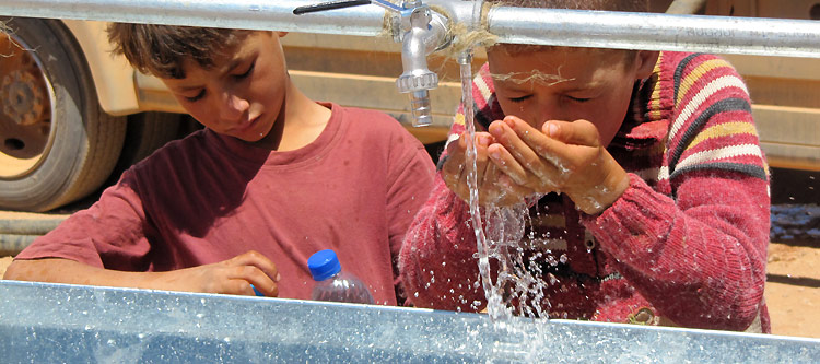 Bustana, North-east Jordanian-Syrian Border. Syrian kids enjoying clean water after the ICRC installed a wash basin at several posts along Jordan’s north-eastern border. / CC BY-NC-ND/ICRC/A. Wagnieres 