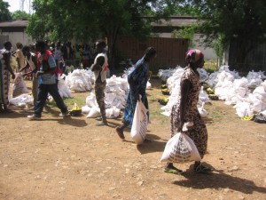 גמבלה, אתיופיה. חברי קהילה מקומית המארחים פליטים מדרום סודן בגמבלה אוספים אספקה מאתר החלוקה של הצלב האדום. 