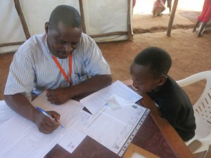 מהאמה, רואנדה. איש שטח של ה-ICRC המופקד על איתור קרובים גובה פרטים מילד בלתי מלווה כדי שניתן יהיה להתחיל בחיפוש אחר משפחתו.  CC BY-NC-ND / ICRC / Emmanuel Kagimbura
