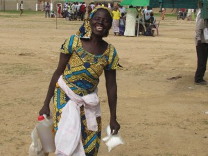 מוגודה, צפון קמרון.  אישה מחייכת בצאתה מנקודת חלוקה עם מזון שאספה מידי ה-ICRC והצלב האדום הקמרוני.  CC BY-NC-ND / ICRC / T. Gnonsian 