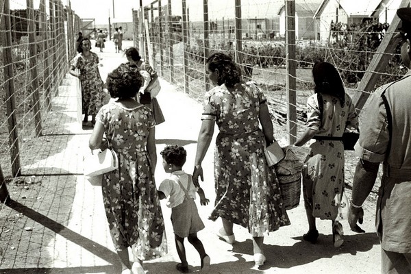 קפריסין, 1958. נשים וילדים מבקרים קרוב משפחה המוחזק במחנה המעצר פּילָה. 