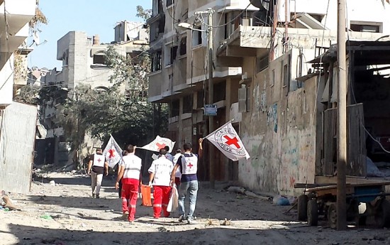 Tim ICRC berjalan menyusuri Shujaia, Gaza, untuk membantu dan menyelamatkan orang-orang.  © ICRC