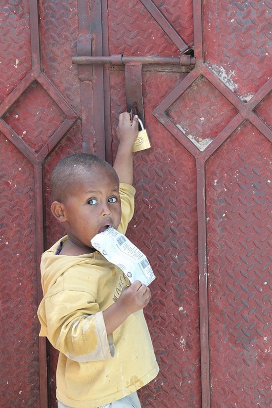 Agensi Passport, Sana'a, Yemen. Seorang anak berdiri di luar sel tahanan ibunya. Pada tahun 2013, ICRC membangun tempat bermain untuk anak-anak ini, yang mana mereka bisa menunggu berbulan-bulan bersama ibunya sebelum dipulangkan. CC BY-NC-ND / ICRC / M-C. Feghali