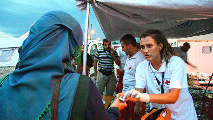 Para relawan Palang Merah memberikan bantuan bahan-bahan medis kepada migran di Macedonia. © Danish Red Cross / John Engedal Nissen