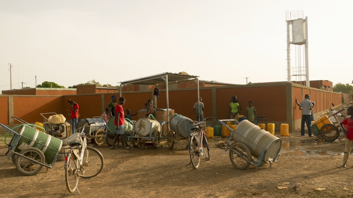 People collecting water at a pumping station.