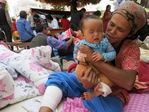 คุณเปมี่ ทามัง จากหมู่บ้านชุมดีในเขตสินธุปัลชอว์กได้รับบาดเจ็บที่ขา เธอกำลังปลอบลูกน้อยให้หยุดร้องไห้ 