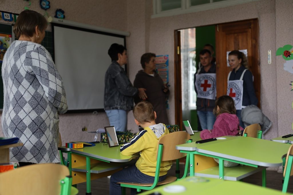 ICRC staff meeting with teachers and kids at one school